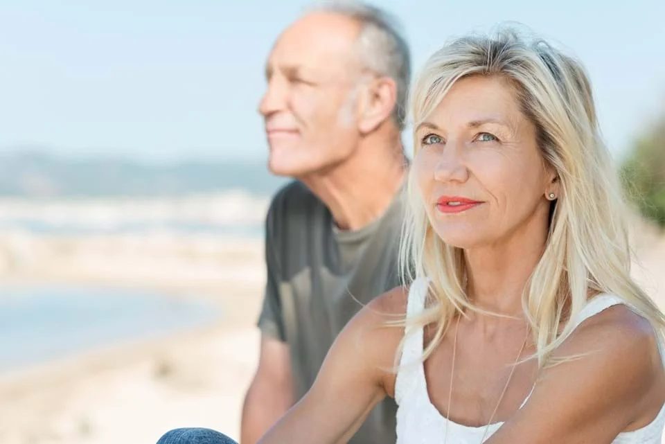 un homme et une femme debout sur une plage